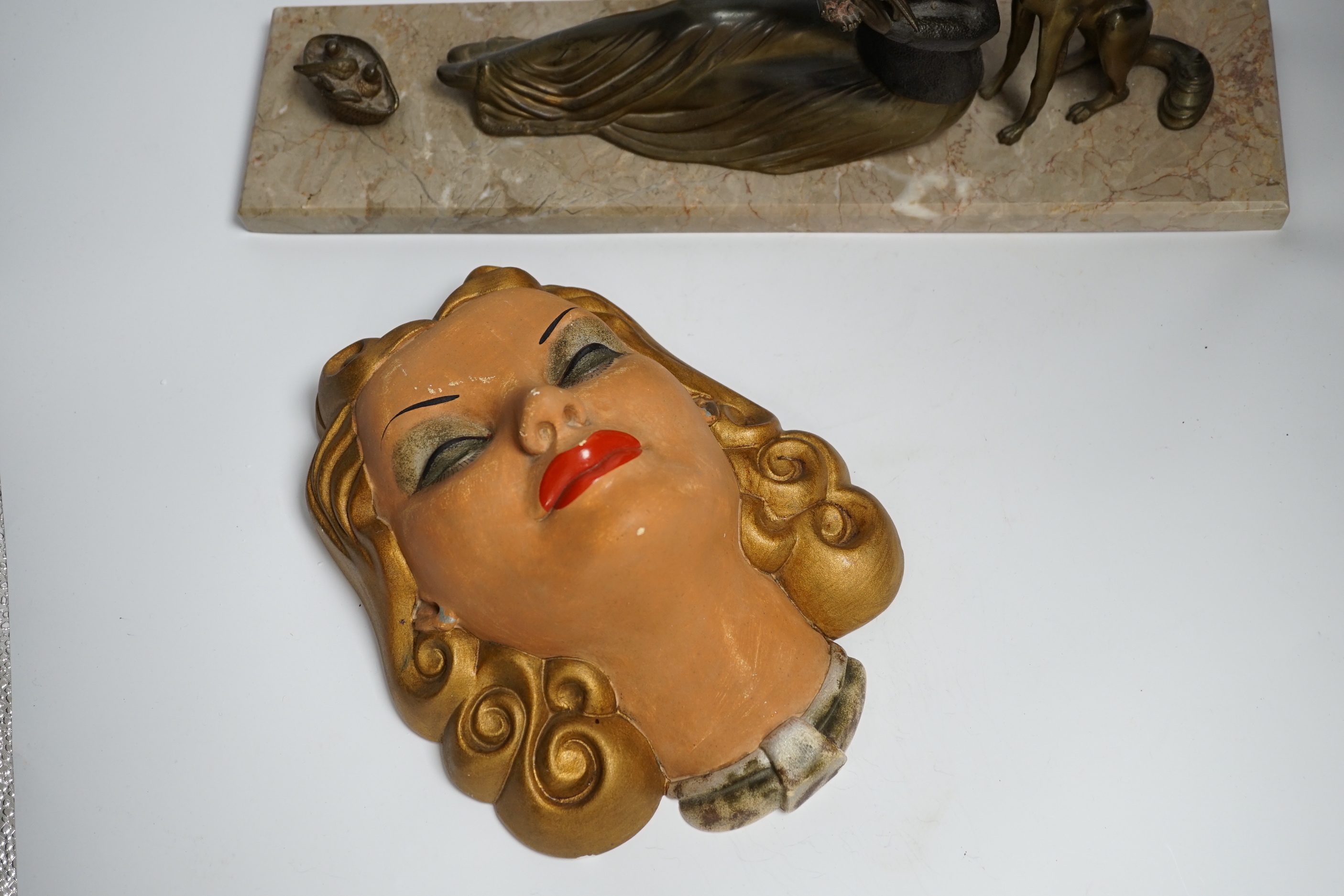 An Art Deco model of a seated lady with a dog and doves, together with a figure of dancing girl and painted plaster face mask, longest 45cm